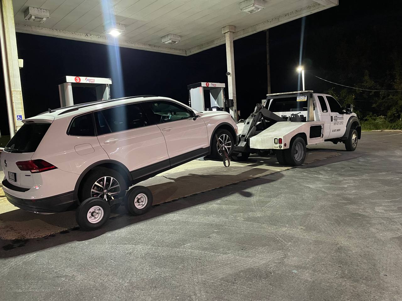 Tow truck towing white car